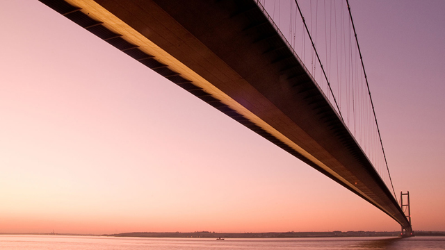 The Humber Bridge seen from below against a pink sky