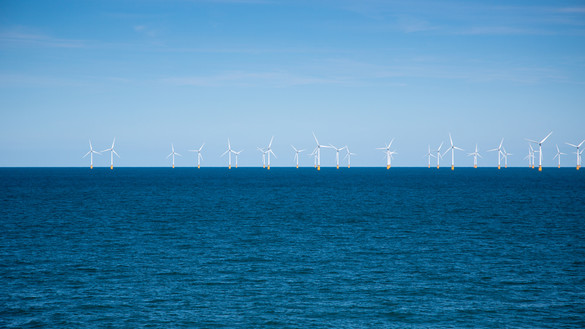 Wind farm in the distance at sea for National Grid 'Green loan speeds race to net zero' story